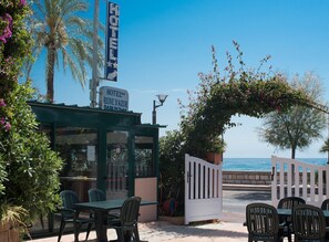 A hotel entrance with a sign reading "HOTEL REINE D'AZUR" and a view of the sea. - Hôtel Reine D'Azur (Roquebrune-Cap-Martin)