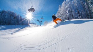 A ski slope with a ski lift and snow-covered trees. - B&B HOTEL Maribor UNI Hostel (Maribor)