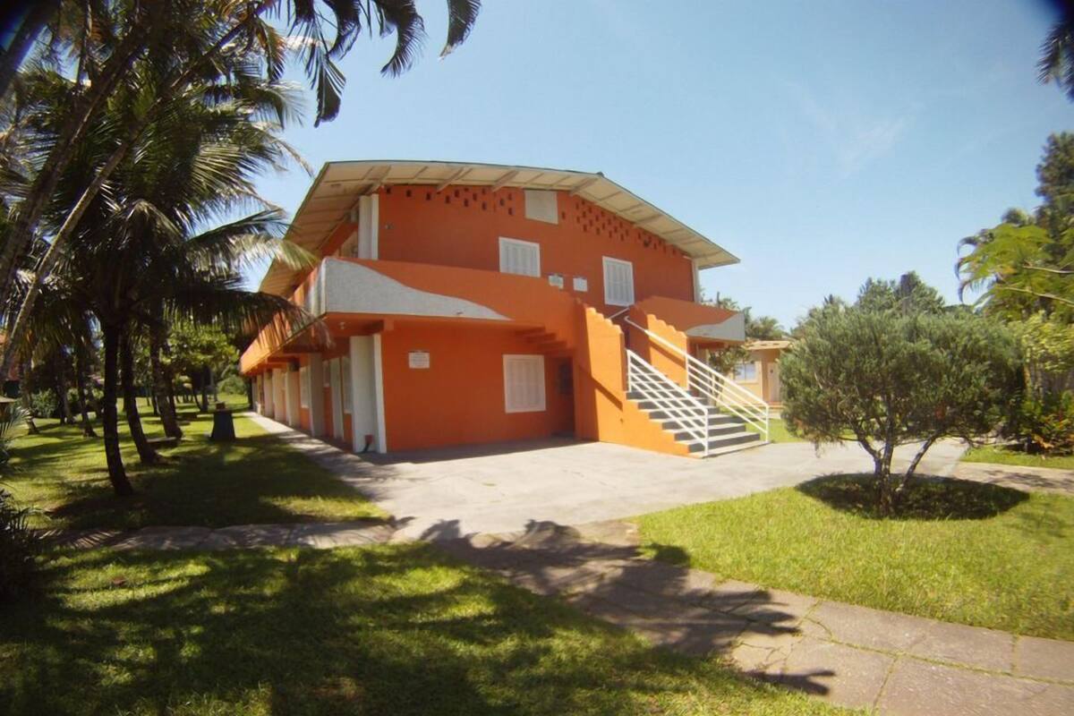 A two-story building with a flat roof and a staircase leading to the entrance.