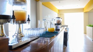 Zona de bar con una máquina de café, una licuadora y varios recipientes de vidrio.