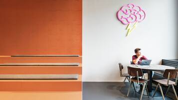 Un interior moderno con una zona de estar que incluye bancos y una mesa redonda con sillas.
