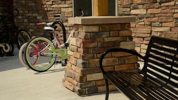 A stone wall with a bench and a bicycle leaning against it.