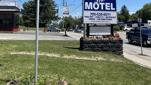 Une enseigne indiquant le « Silver Star Motel », avec les commodités suivantes : accès Wi-Fi gratuit, télévision par câble, four à micro-ondes, réfrigérateur et climatisation.