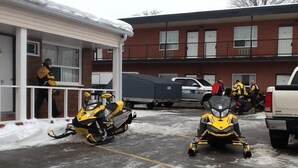 Un bâtiment doté d’une entrée abritée et d’un espace de stationnement dont le sol est recouvert de neige.