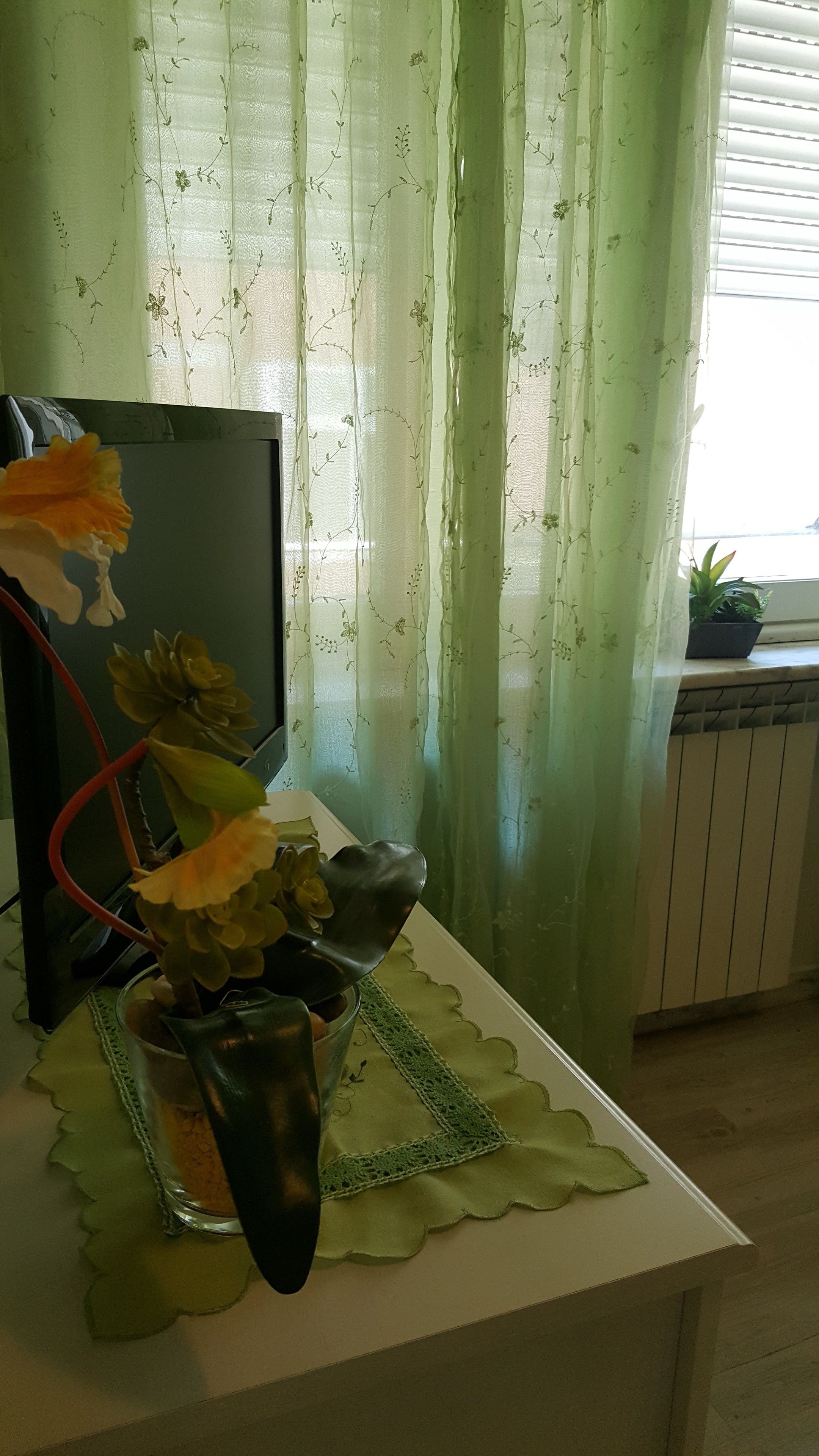 A table with a potted plant and a glass container.