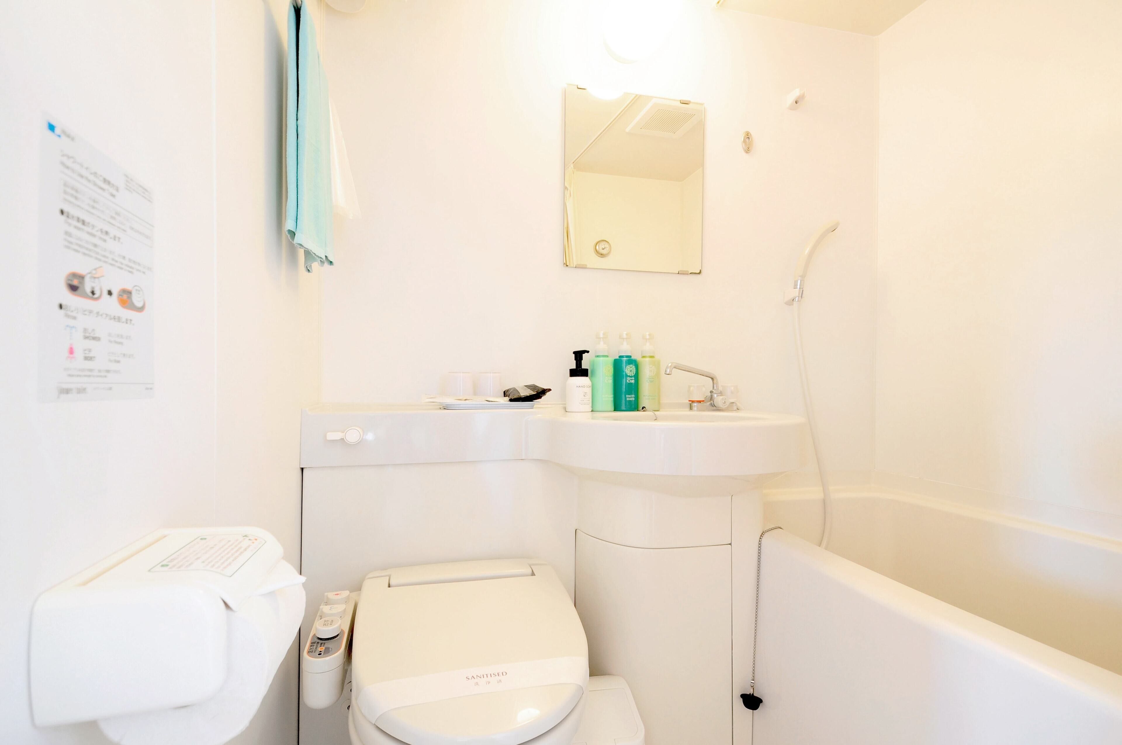 Une salle de bain avec des toilettes, un lavabo et une baignoire.