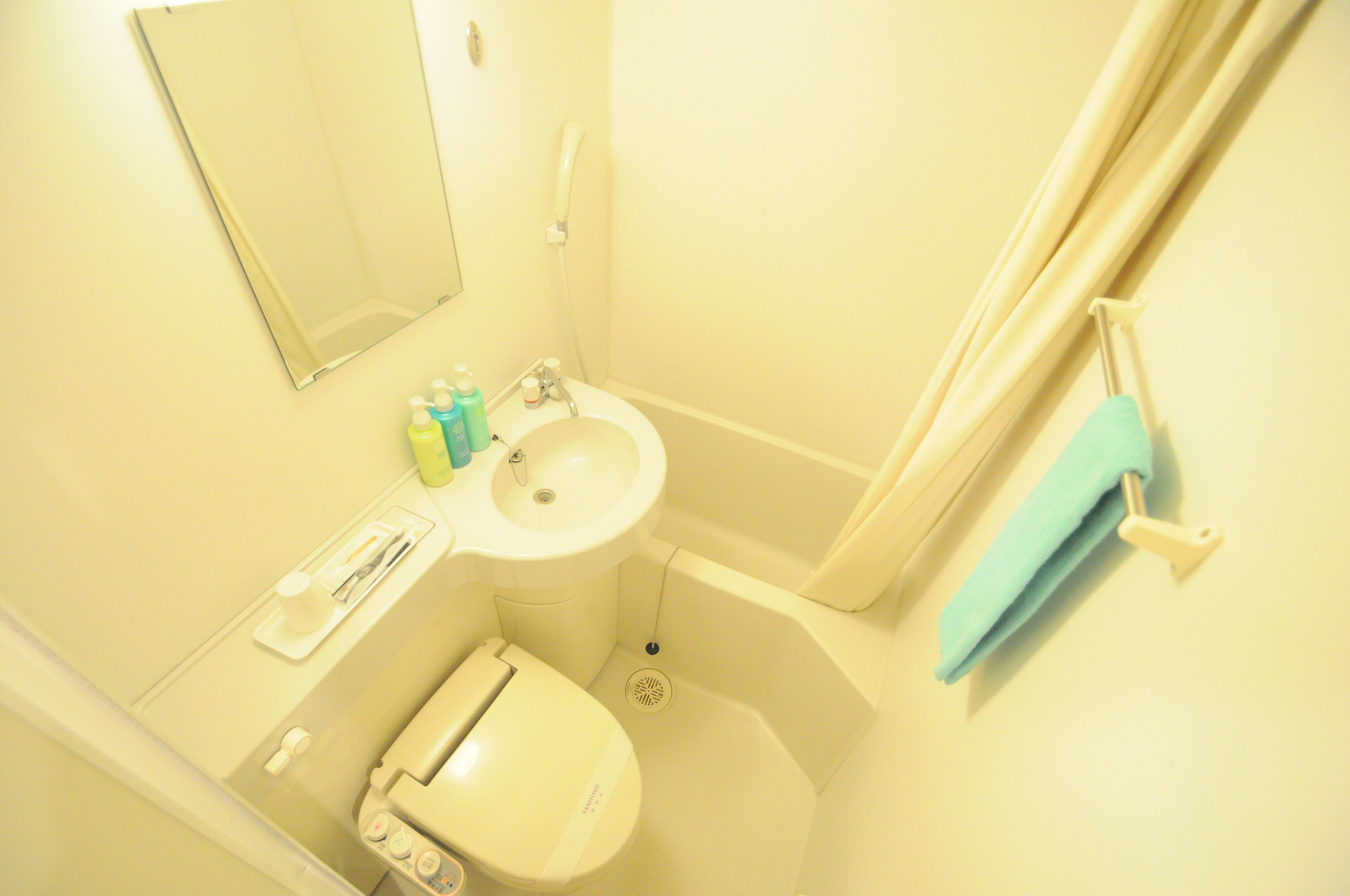 A small bathroom with a toilet, sink, and shower.