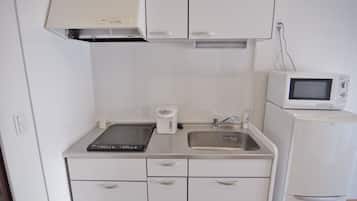 Frigorífico grande, microondas, placa de cocina y utensilios de cocina