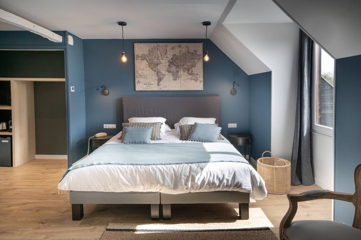A bedroom with a large bed, a world map on the wall, and a skylight.