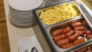 Ein Buffet mit verschiedenen Speisen, darunter Fleisch, Obst und Getränke.