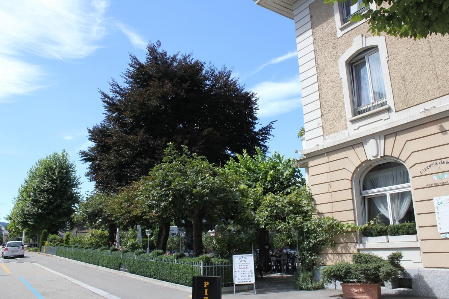A building with a sign for 'Pizzeria da Maria' and a sign for 'Hotel Restaurant'.