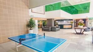 A ping pong table in a hotel lobby with a reception desk, seating area, and a green-tiled ceiling. - Eurotel Boracay (Boracay Island)