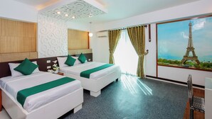 A hotel room with two beds, a large window with curtains, a painting of the Eiffel Tower, and a small table with a chair. - Eurotel Boracay (Boracay Island)