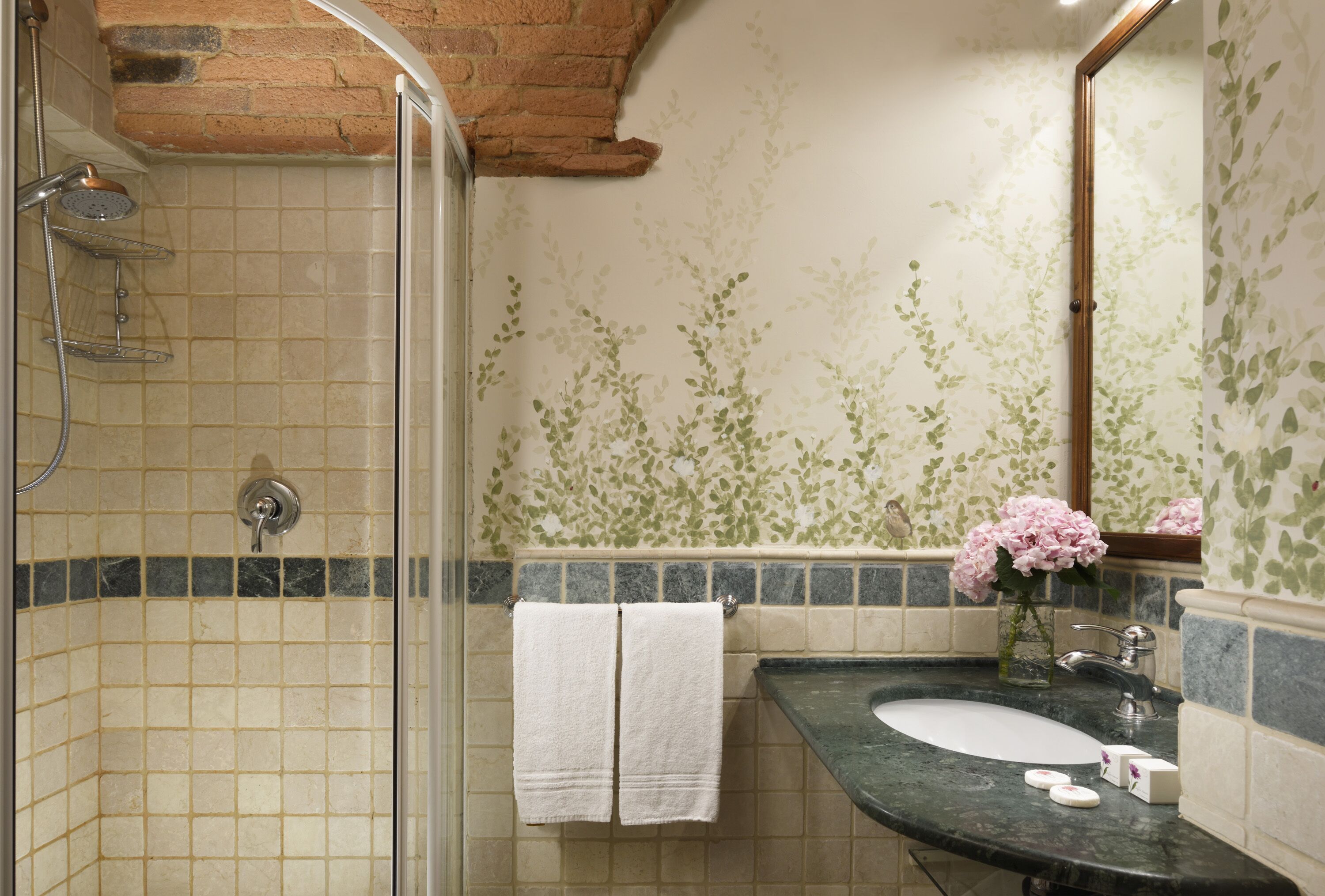 A bathroom with a shower, a sink, and a mirror.