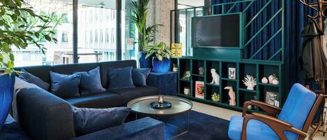 A modern living room with a sofa, armchair, coffee table, and a TV.