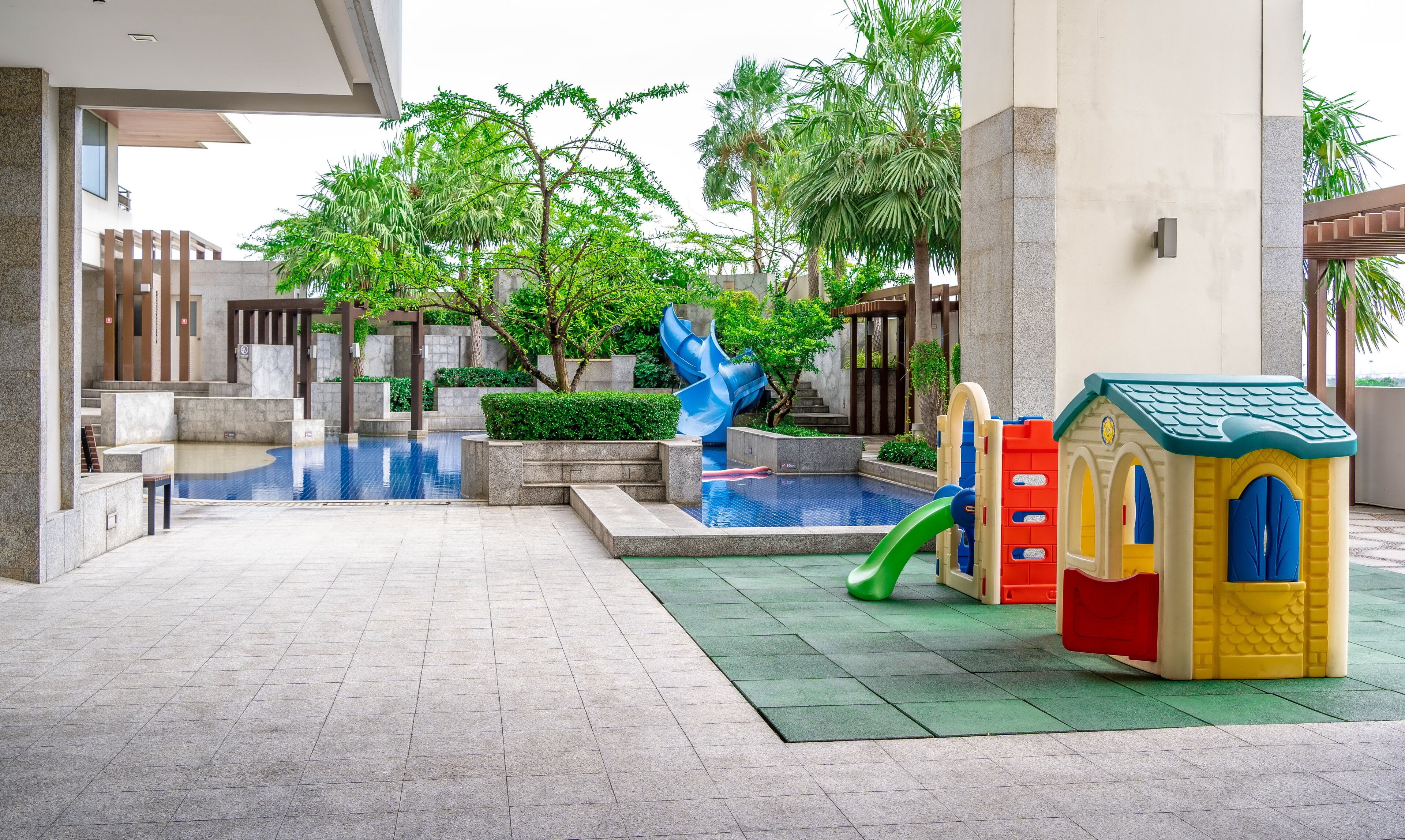 A children's play area with a slide, a small pool, and a playhouse.