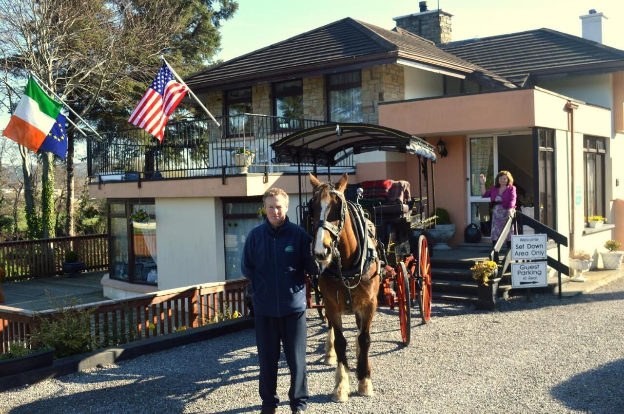 Un bâtiment doté d’un balcon, un attelage tiré par des chevaux et des drapeaux de l’Irlande et des États-Unis.