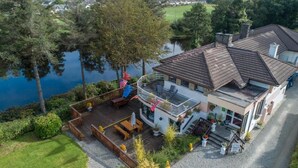 A house with a deck, a balcony, and a view of a lake. - Killarney View House B&B (Killarney)