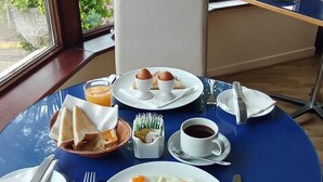 A breakfast table with eggs, sausages, bacon, beans, toast, and coffee. - Killarney View House B&B (Killarney)