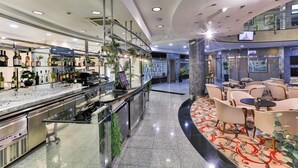 A modern bar area with a glass counter, stainless steel appliances, and a variety of bottles. - KINGS PARK HOTEL (Podgorica)