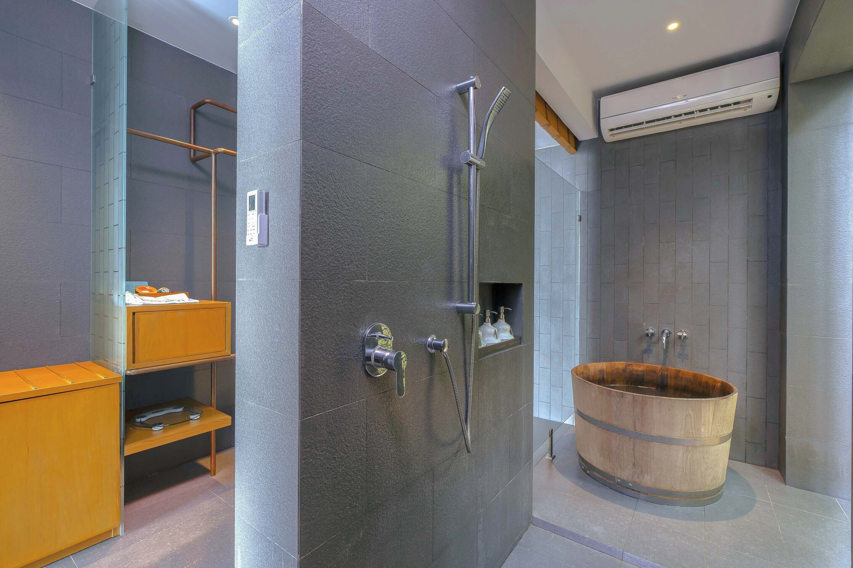A modern bathroom with a wooden bathtub, a glass shower enclosure, and a built-in shelf with toiletries.