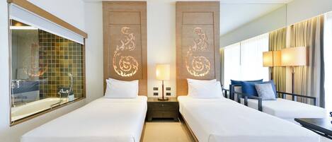 A hotel room with two beds, a nightstand with a lamp, a mirror, a window with curtains, and a view of the outside.