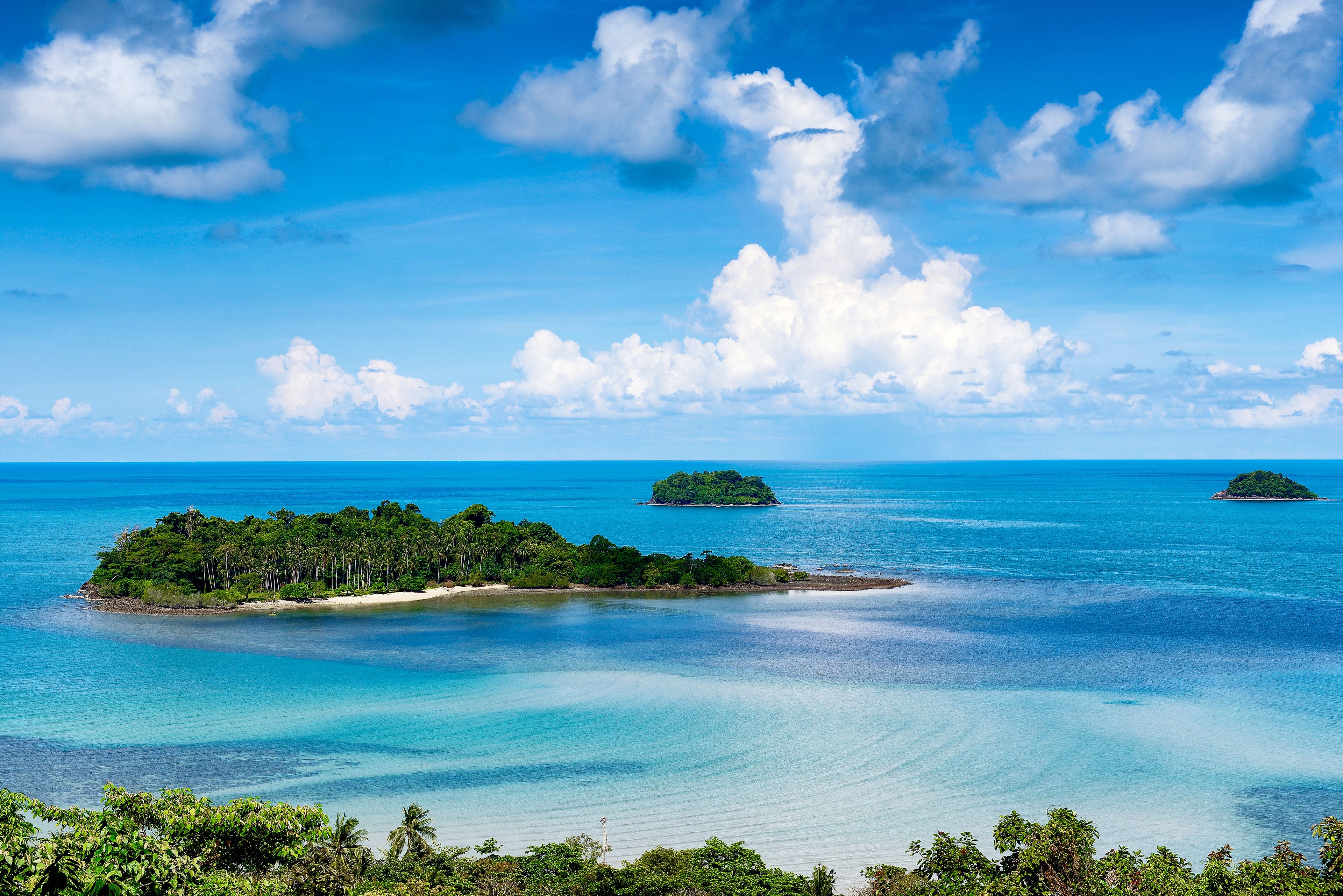 A tropical island with clear blue waters and lush greenery.