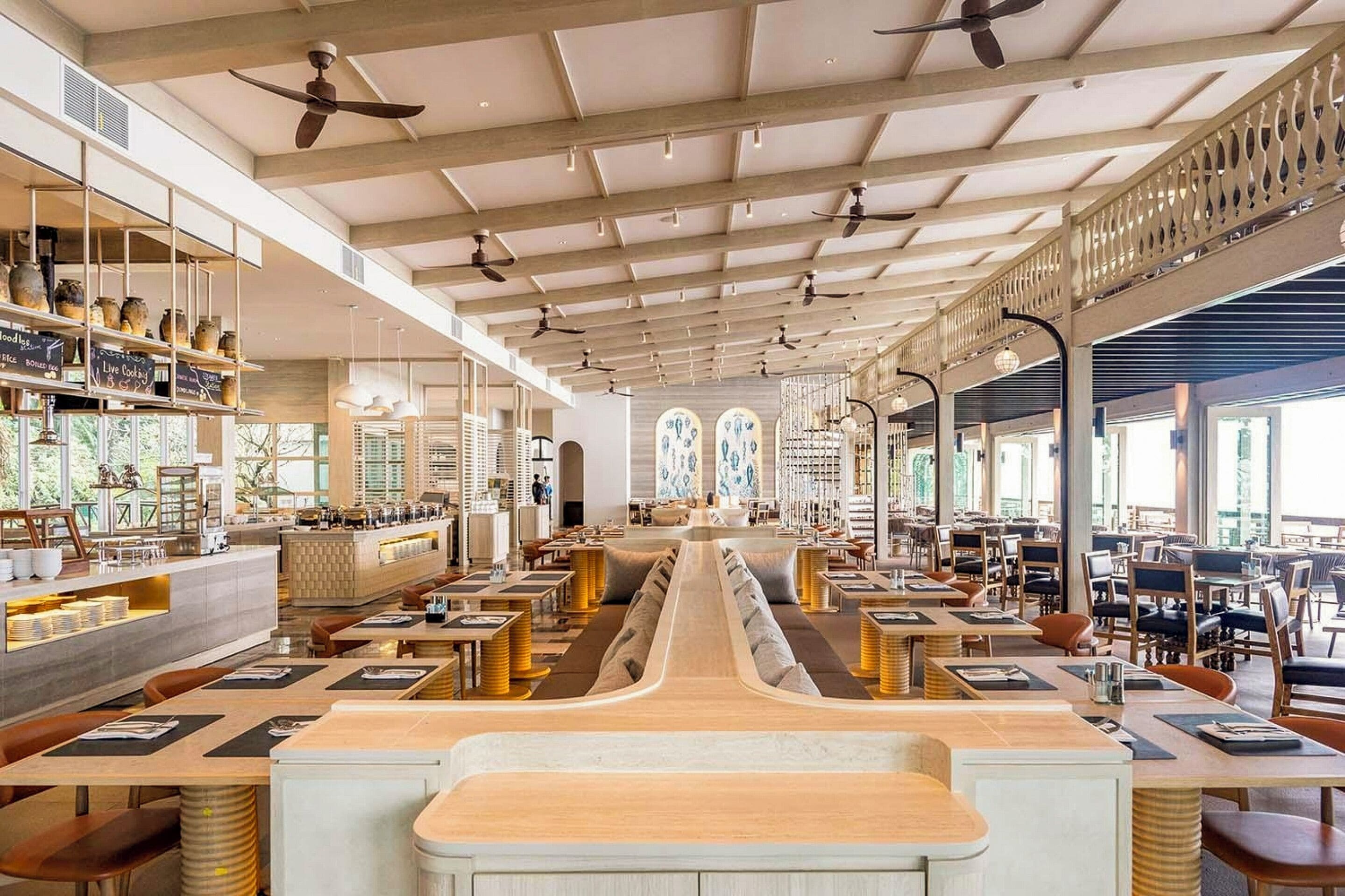 Ein geräumiges Restaurant mit hohen Decken, verschiedenen Sitzbereichen und einem zentralen Gang.