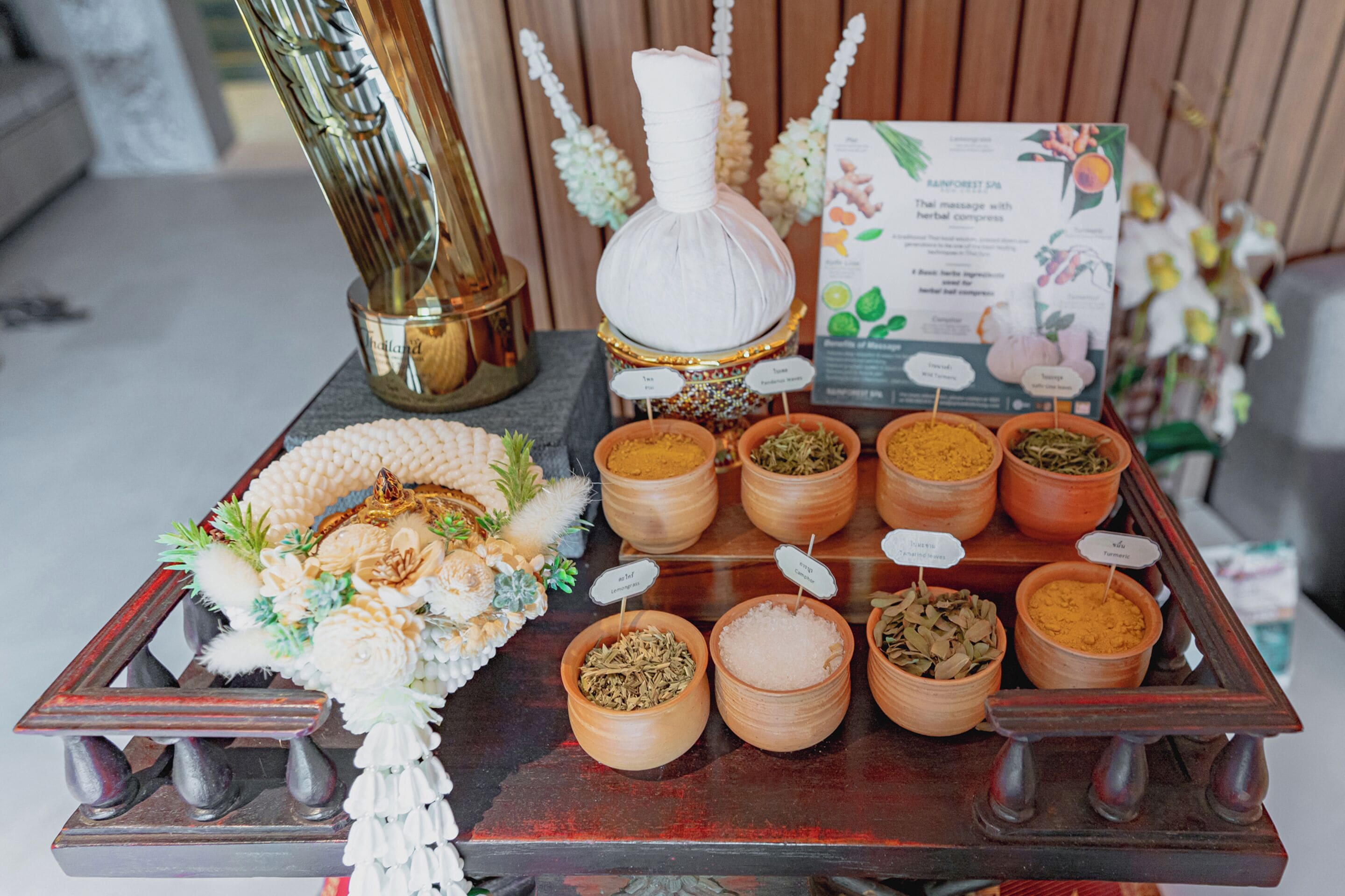 A display of various herbs and spices in small containers, each labeled with their names.