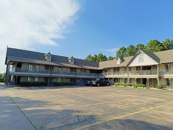 A large, two-story building with multiple balconies and a parking lot in front. - Victorian Inn (Athens)