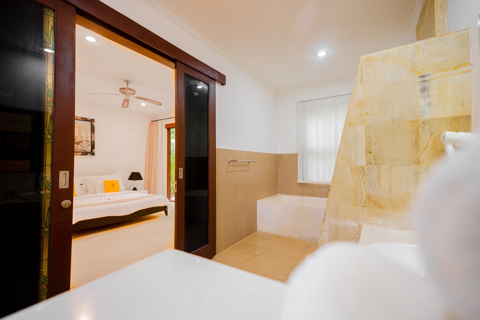 Una habitación de hotel con cama, baño con bañera y zona de ducha.