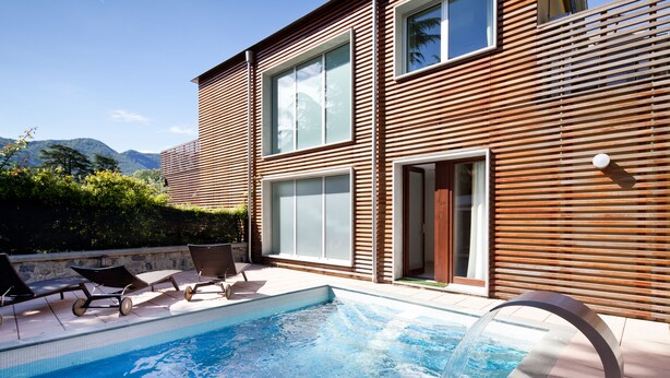 A modern house with a swimming pool, wooden exterior, and a view of mountains. - Residence Lenno (Tremezzina)