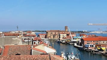 A coastal town with buildings along the waterfront, a marina with boats, and a crane in the background.