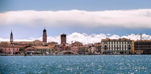 A waterfront cityscape with historic buildings, a prominent tower, and a bridge.