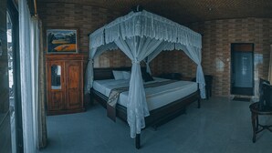 A room with a four-poster bed, a wooden cabinet, and a painting on the wall. - Segara Hotel and Restaurant (Kintamani)