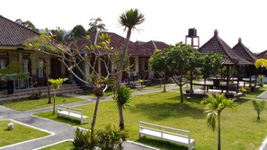 A courtyard with a traditional building, a water tank, and a gazebo. - Segara Hotel and Restaurant (Kintamani)