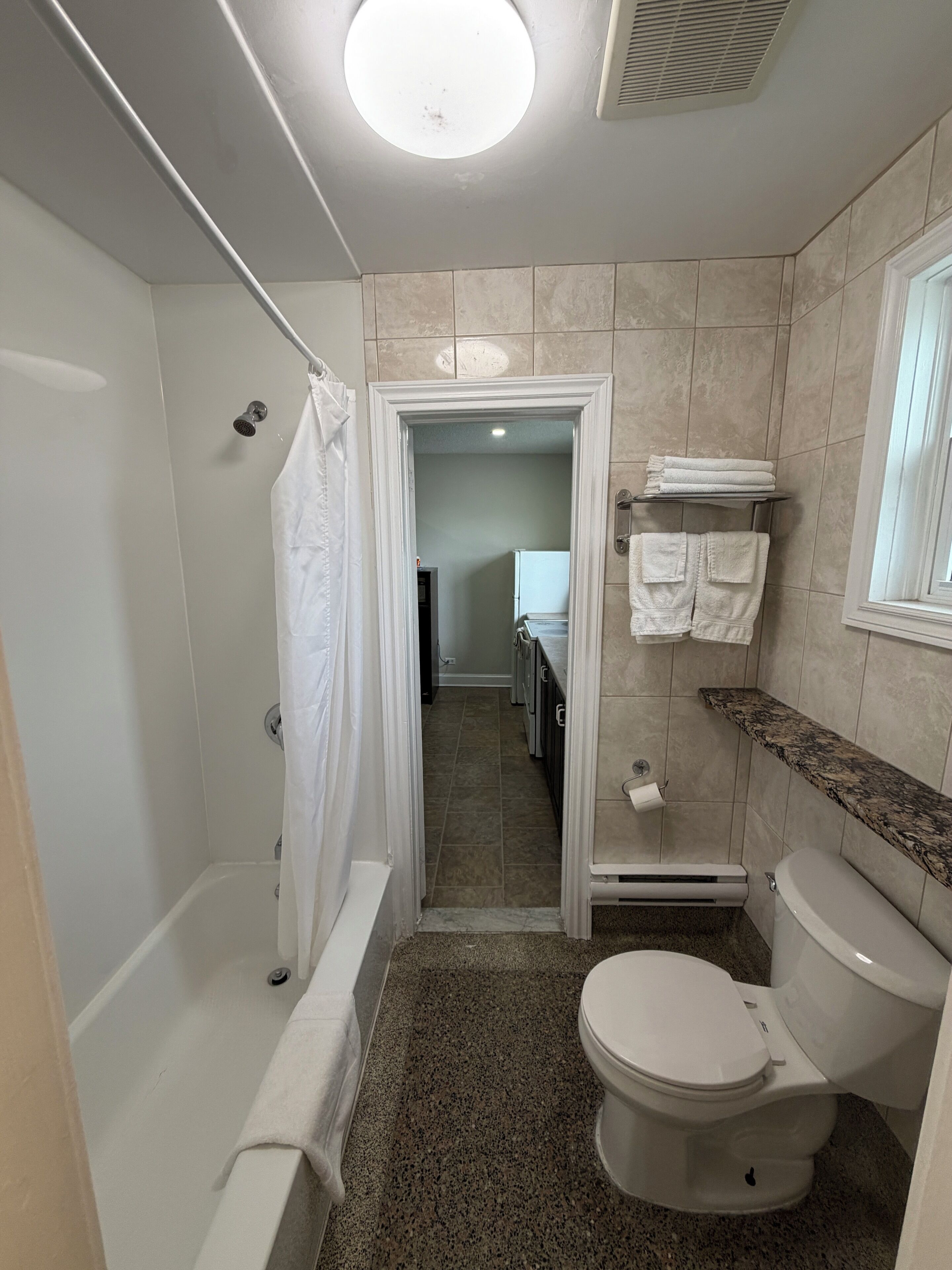 Un baño con bañera, inodoro y cortina de ducha.
