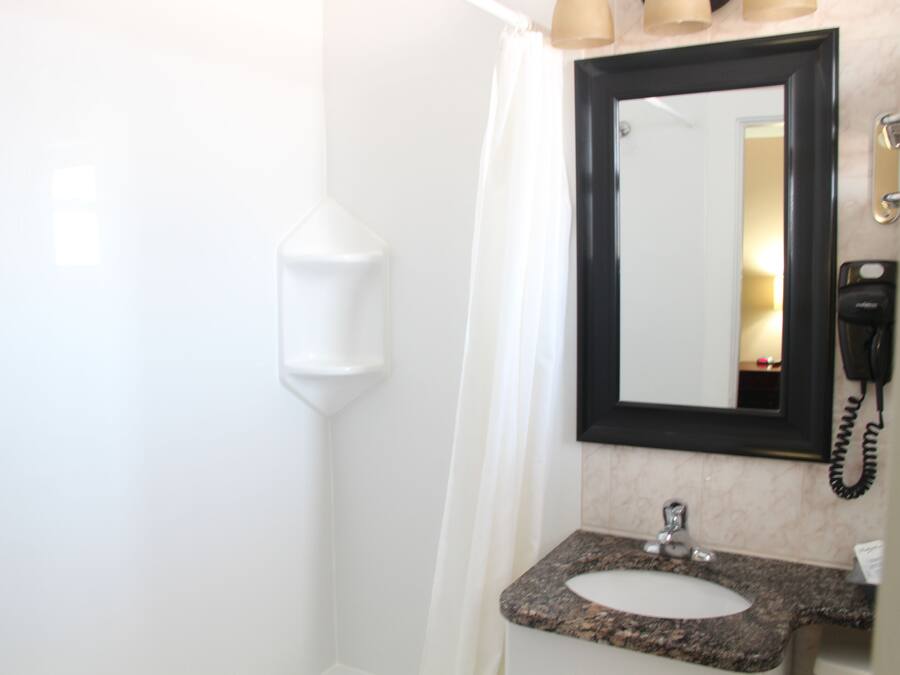 A bathroom with a white sink, a mirror, and a telephone.