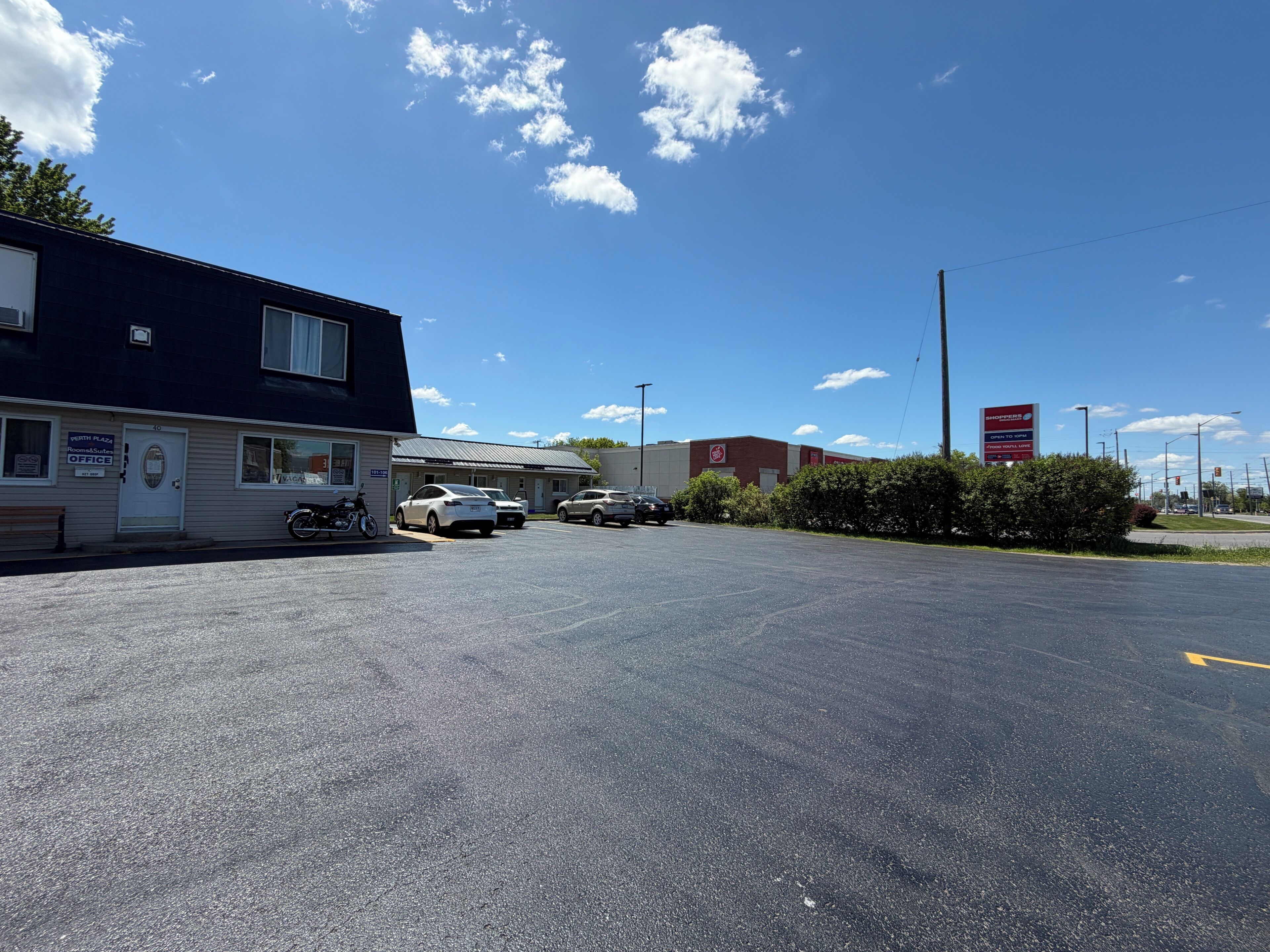 A parking lot with a building labeled 'Perth Plaza Office' and a sign for 'Shoppers Drug Mart.'
