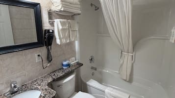 Een badkamer met een wastafel, toilet en bad.