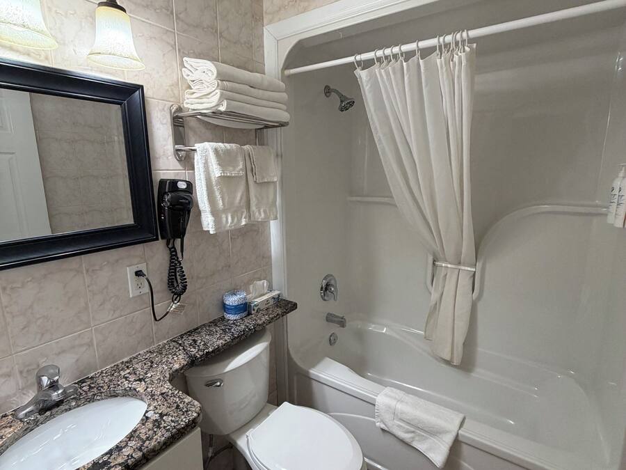 Een badkamer met een wastafel, toilet en bad.