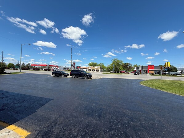 Un estacionamiento con McDonald's y KFC, una gasolinera y un cielo azul despejado.