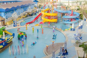 A water park with multiple slides and pools, surrounded by lounge chairs and umbrellas. - Swiss Inn Teda Hotel & Aquapark (Ataqah)