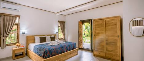 A bedroom with a wooden bed, a nightstand, a wardrobe, and a view of the outdoors.