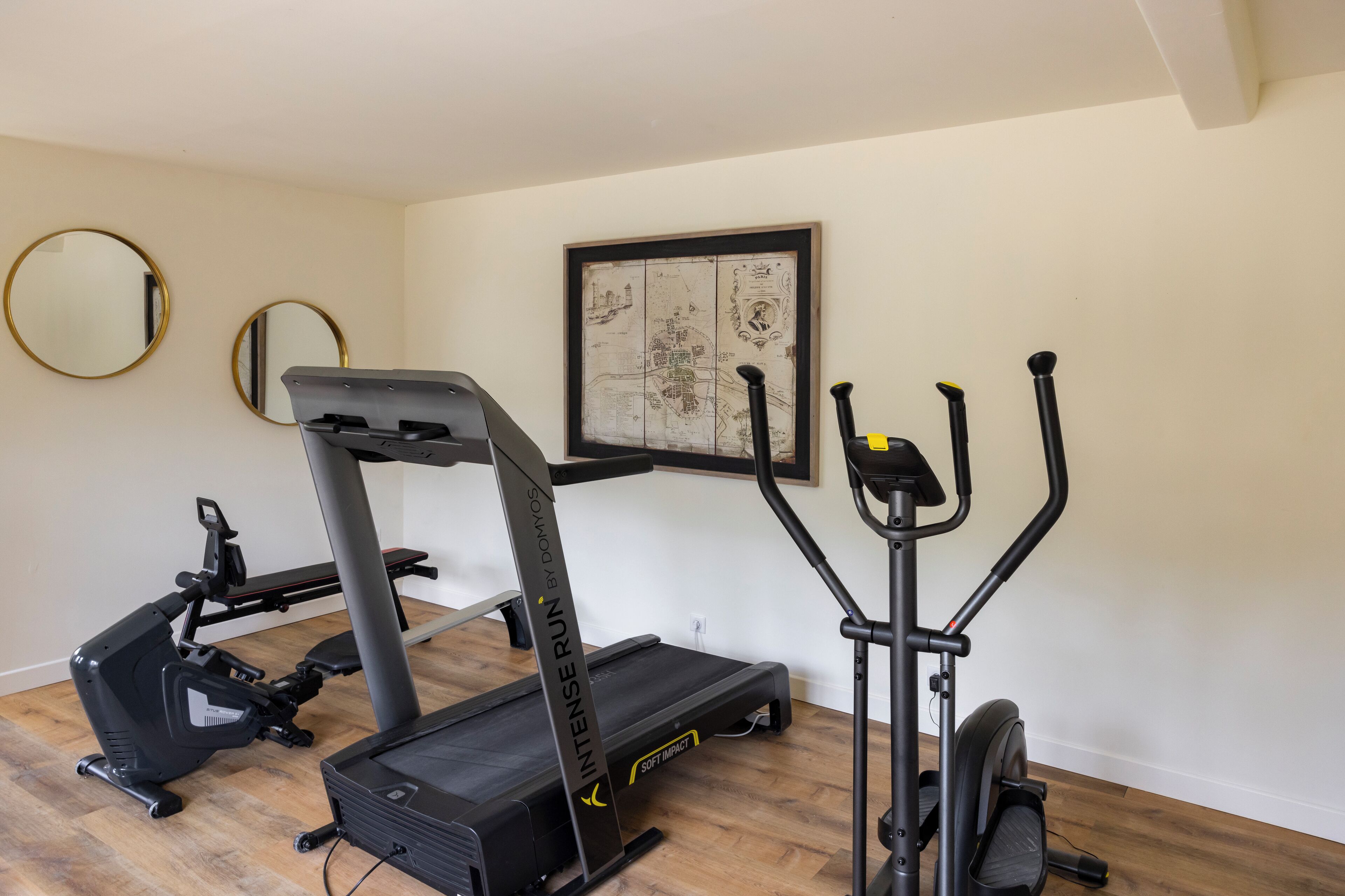 A home gym with a treadmill, elliptical, and stationary bike.