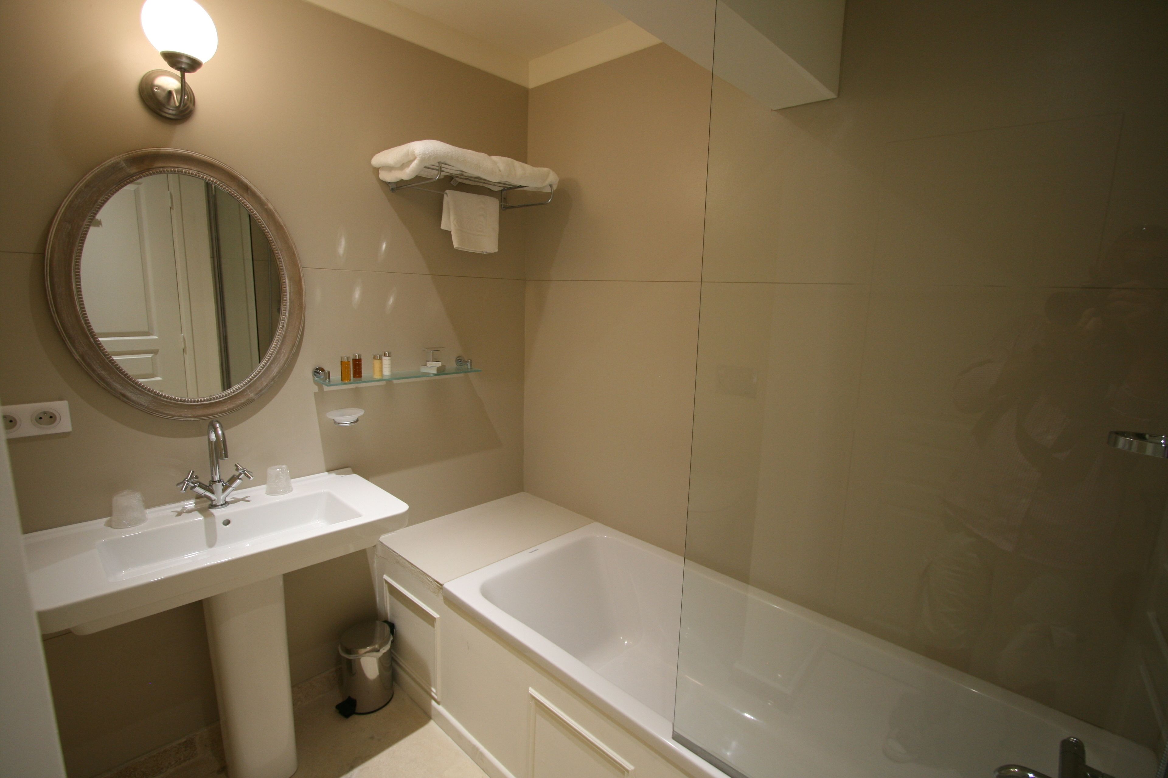 Ein Badezimmer mit Waschbecken, Spiegel und Badewanne.