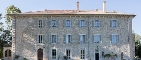 A large stone building with multiple windows and a central entrance.