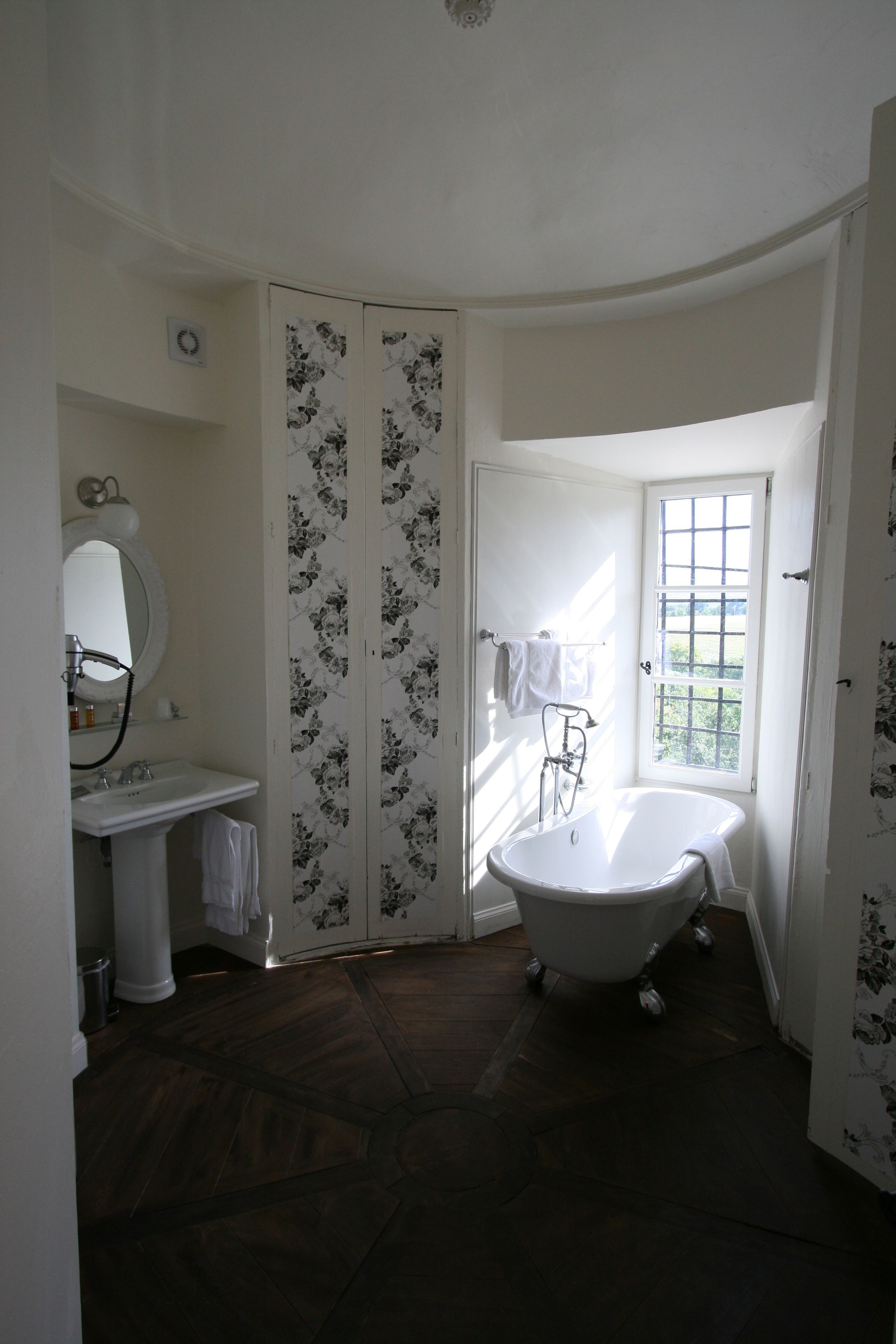 Une salle de bain avec une baignoire sur pieds, un lavabo et un miroir.