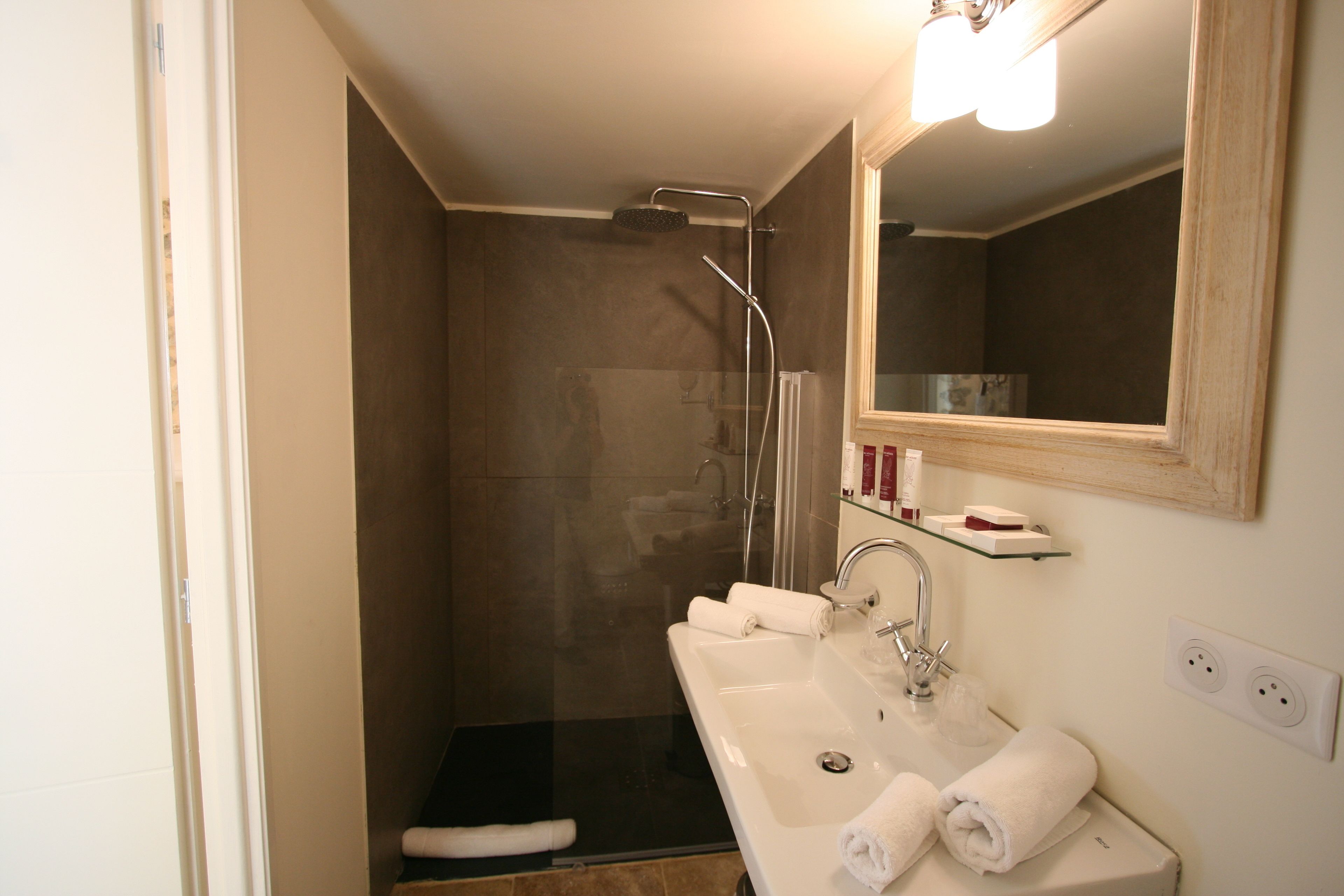 A bathroom with a shower, sink, and mirror.