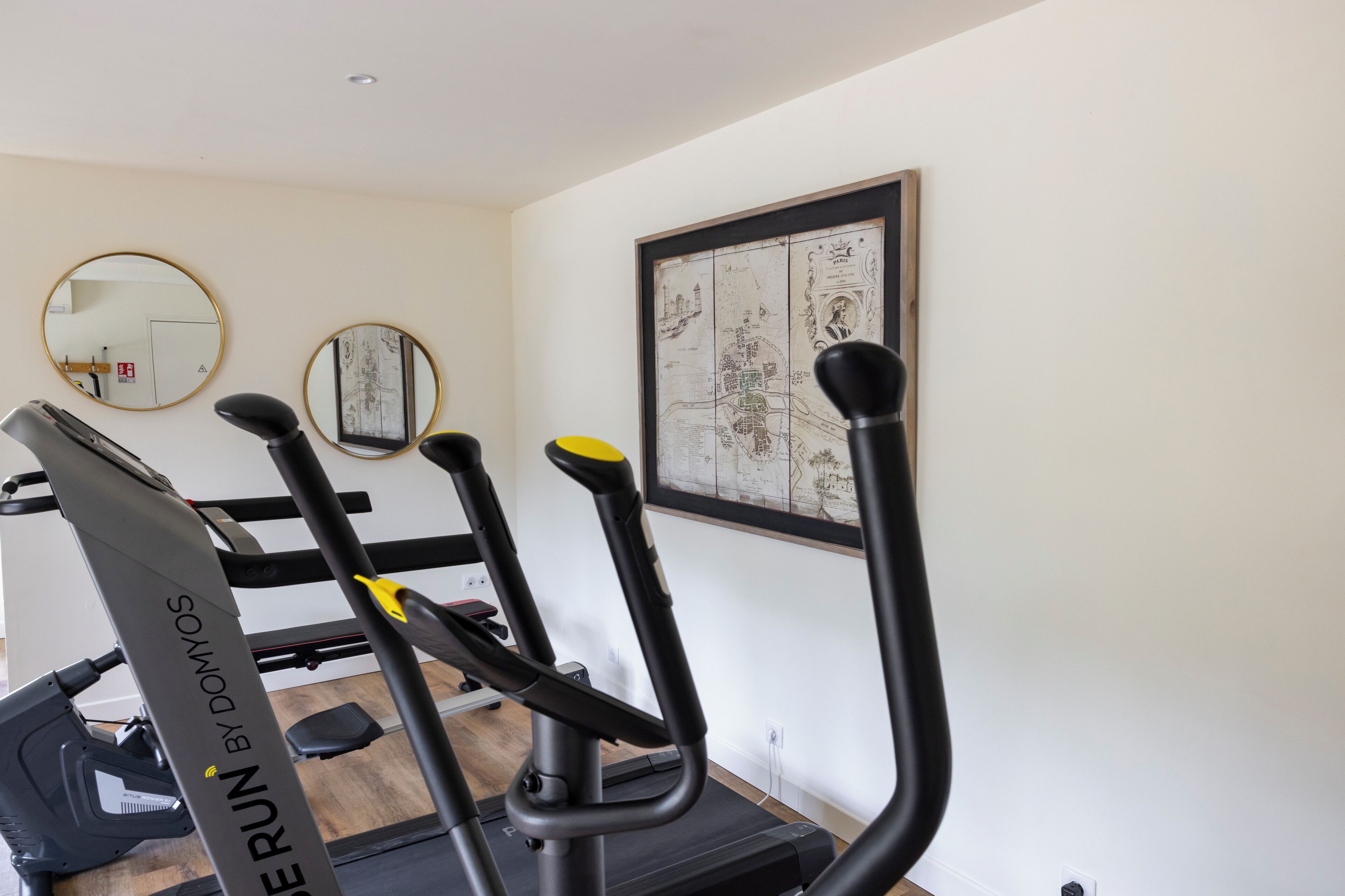 A home gym with treadmills, a stationary bike, and a mirror.